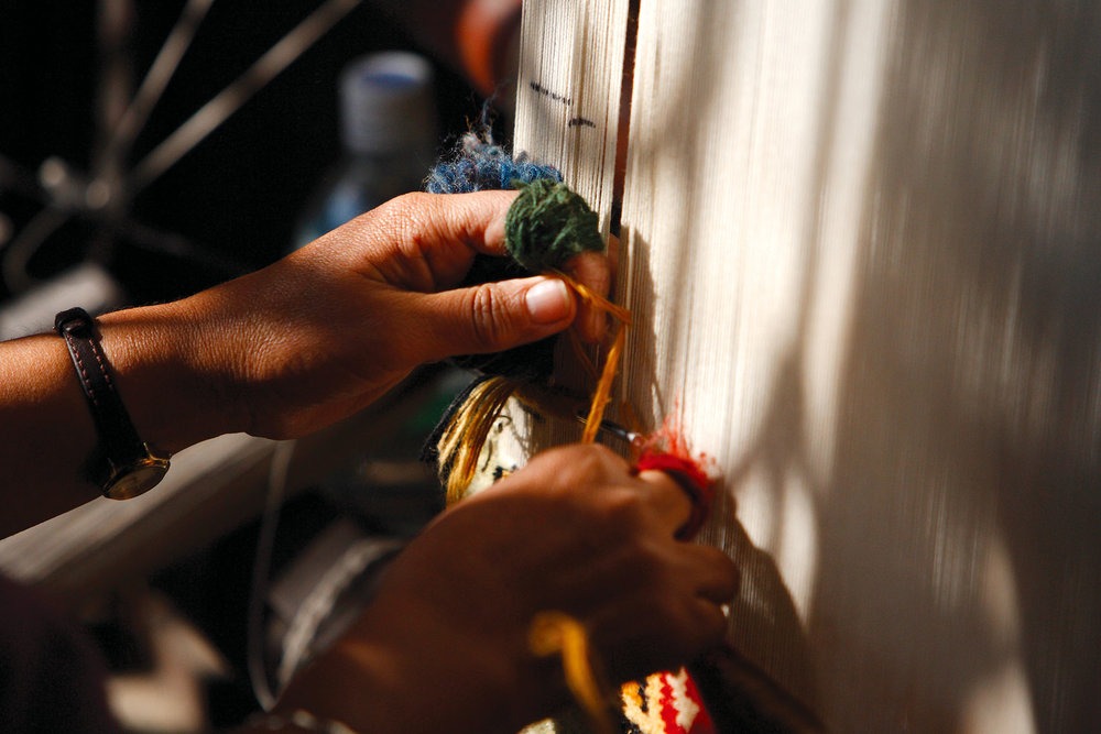 Hands working at a carpet loom, from the COTO presentation